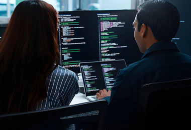 Developers collaborating at automated monitors